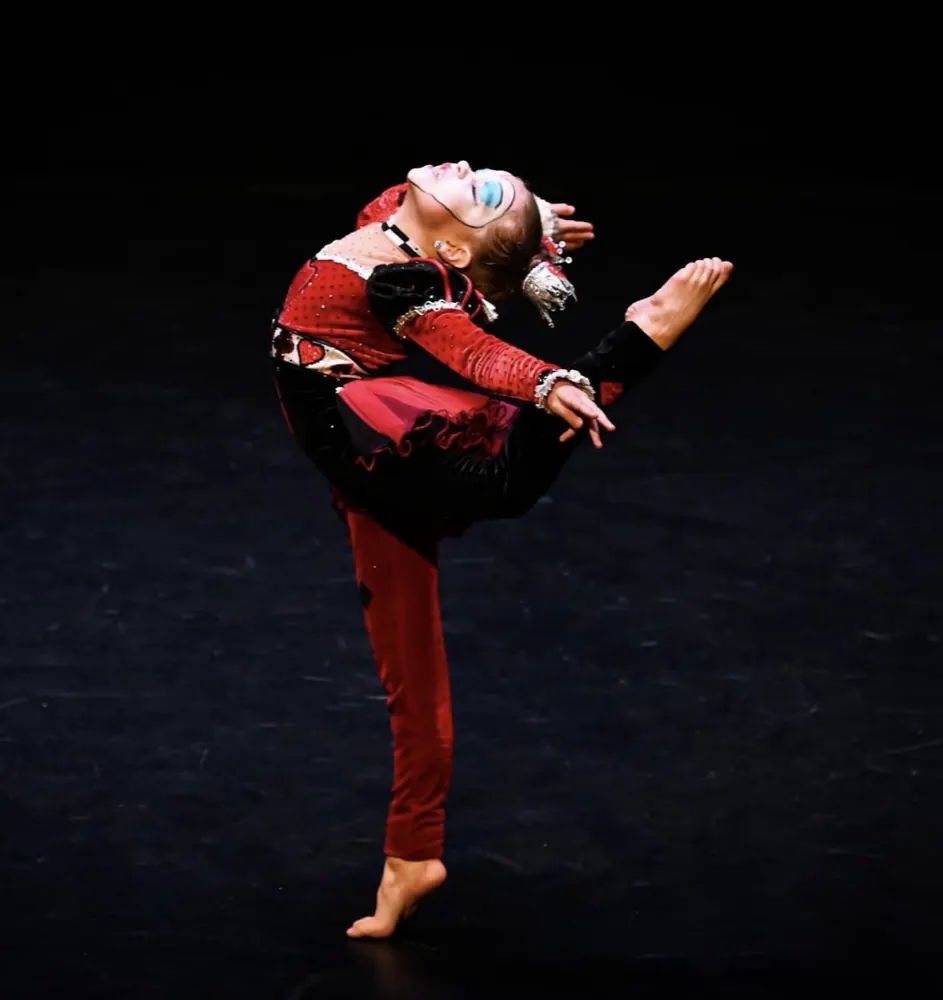 A dancer mid-jump in a red costume